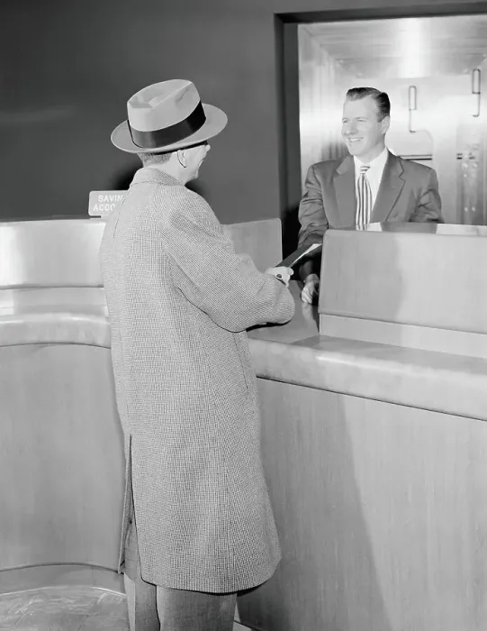 Framed Print : Man talking to teller in bank, vault in background Framed Print : Man talking to teller in bank, vault in background