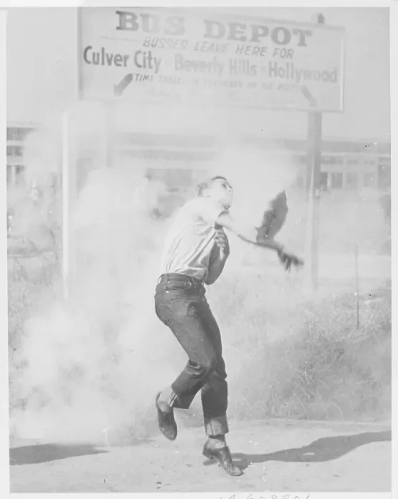 Framed Print : Man Throwing Tear Gas Bomb At Police