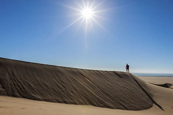 Man walking in the dune belt of Long Beach, Swakopmund, Namibia