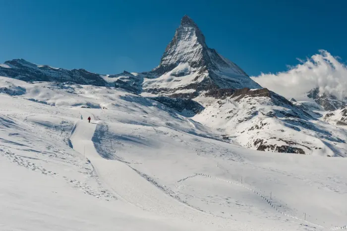 Framed Print : a man walking on a snow trail with Matterhorn background Framed Print : a man walking on a snow trail with Matterhorn background