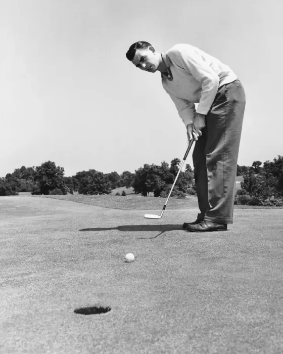 Framed Print : Man watching golf ball after hitting it with putter Framed Print : Man watching golf ball after hitting it with putter