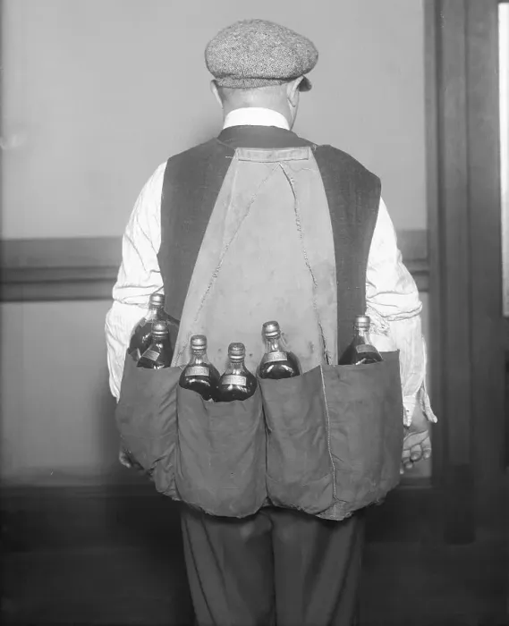 Framed Print : Man Wearing Coat Holding Bottles Framed Print : Man Wearing Coat Holding Bottles