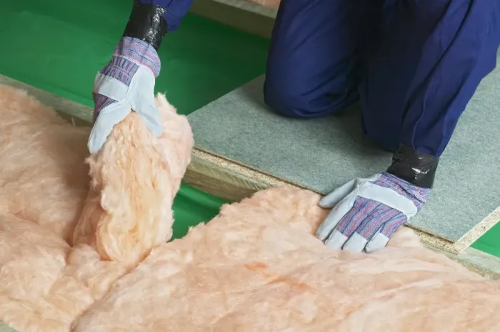 Framed Print : Man wearing overalls, gloves joining end of insulation blanket together