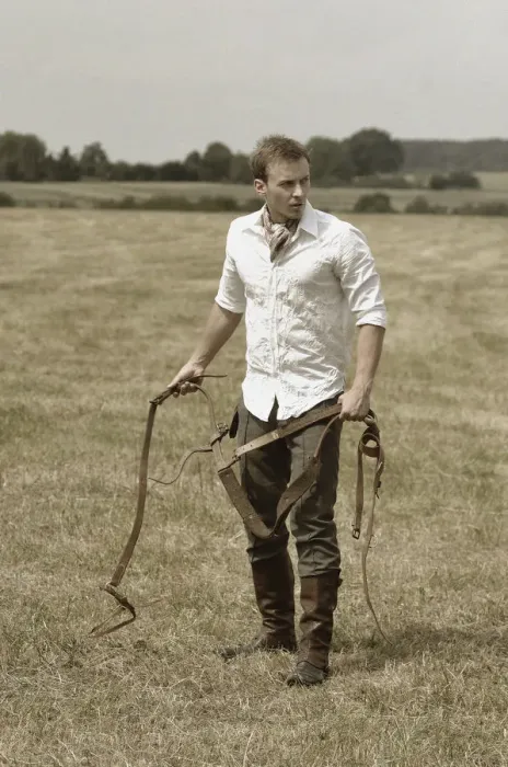 Framed Print : Man wearing riding clothes standing in a field in summer holding a leather strap Framed Print : Man wearing riding clothes standing in a field in summer holding a leather strap