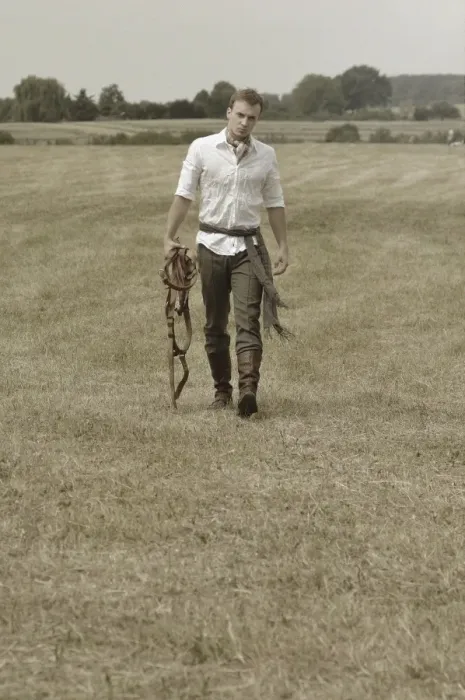 Framed Print : Man wearing riding clothes walking in a field in summer Framed Print : Man wearing riding clothes walking in a field in summer