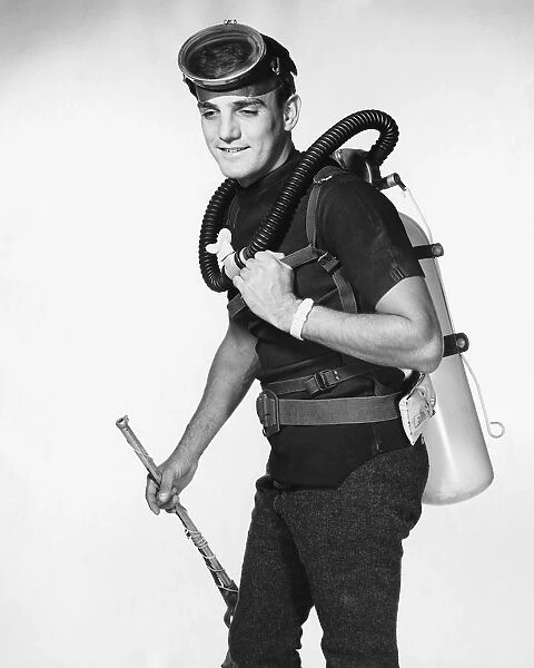Man wearing scuba gear, carrying speargun
