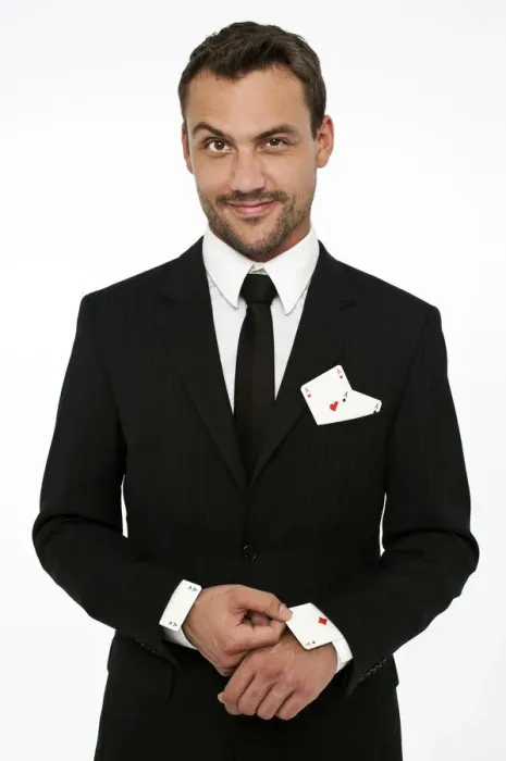 Framed Print : Man wearing a suit pulling an ace of diamonds out of his sleeve with other aces in his pocket