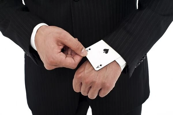 Man wearing a suit pulling an ace of spades out of his sleeve