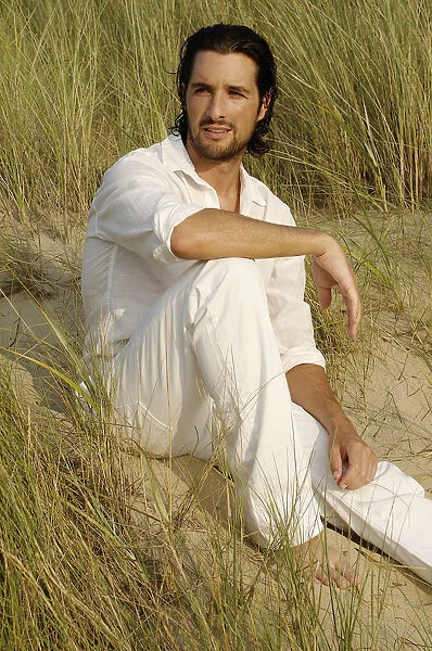 Man wearing white clothes sitting in the dunes