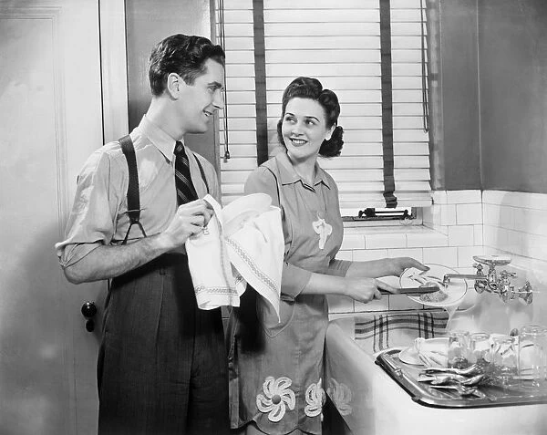 Man and woman doing dishes in kitchen