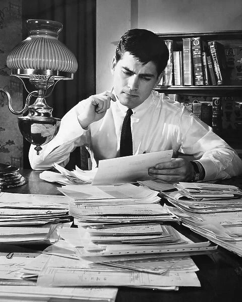 Man working at desk covered with files