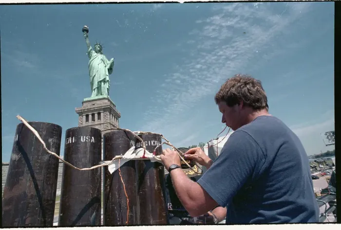 Framed Print : Man Working on Fence near Statue of Liberty