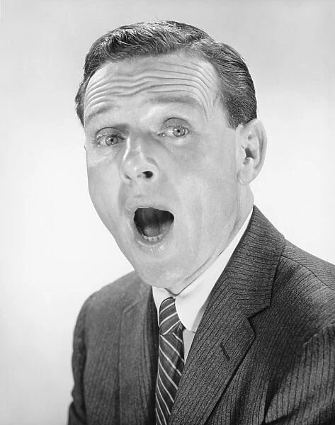 Man yawning, posing in studio, (B&W), portrait
