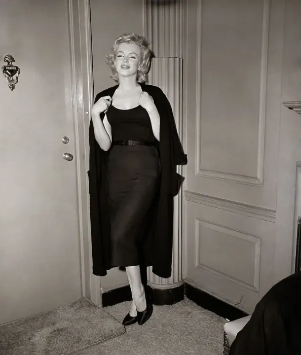 Framed Print : Marilyn Monroe Holding Sweater By Door Framed Print : Marilyn Monroe Holding Sweater By Door