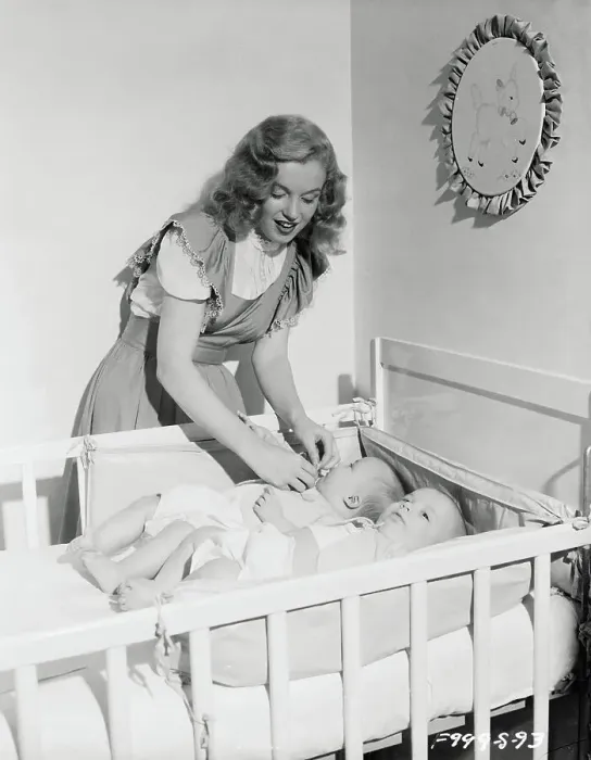 Framed Print : Marilyn Monroe Standing over Babies in Crib Framed Print : Marilyn Monroe Standing over Babies in Crib