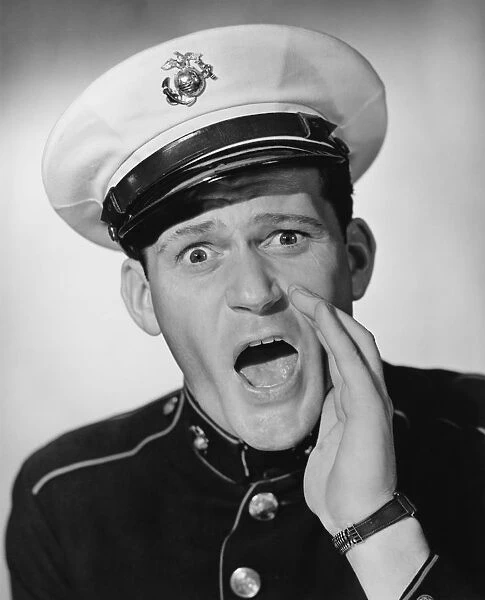 Marine in military uniform screaming in studio, (B&W), portrait