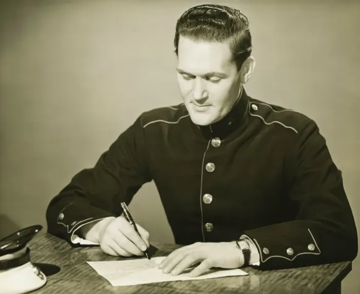 Framed Print : Marine in military uniform writing letter at desk, (B&W) Framed Print : Marine in military uniform writing letter at desk, (B&W)