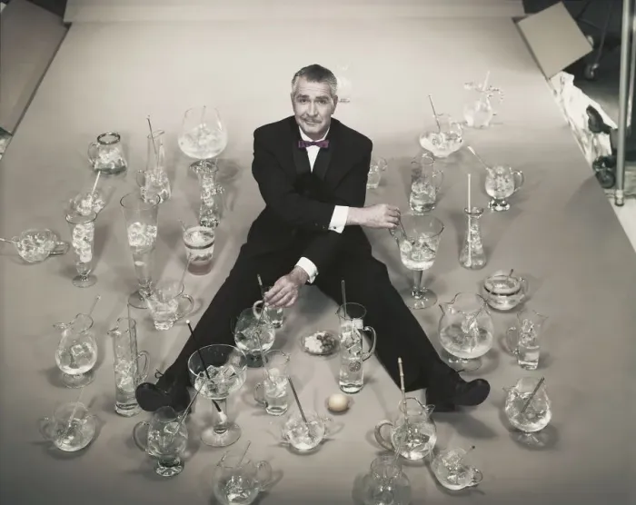 Framed Print : Mature man sitting with stirring glasses of ice Framed Print : Mature man sitting with stirring glasses of ice