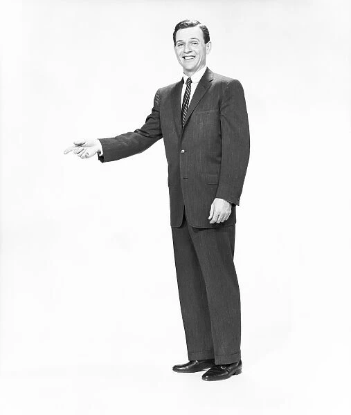 Mature man wearing suit, standing in studio, portrait