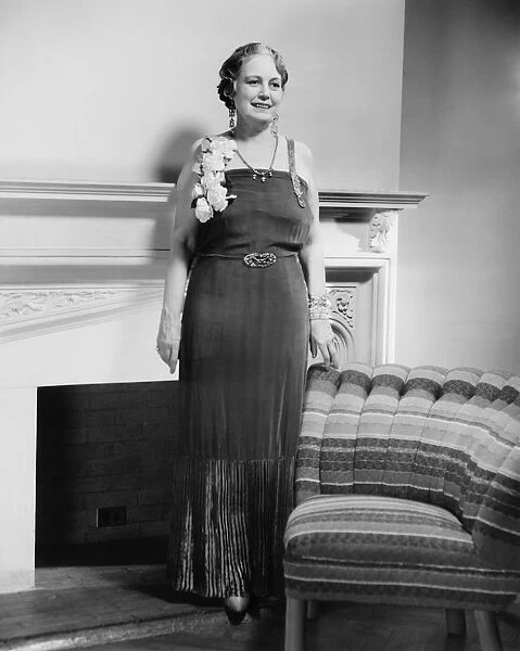 Mature woman in evening gown posing at fireplace (B&W), portrait