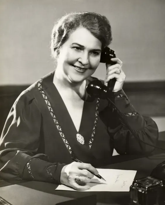 Framed Print : Mature woman on telephone and writing note