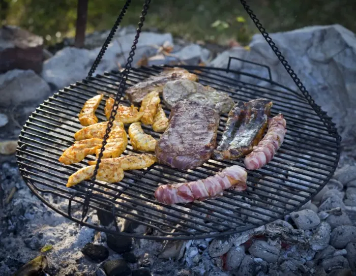 Framed Print : Meat and sausages being cooked on a grill hanging on chains Framed Print : Meat and sausages being cooked on a grill hanging on chains