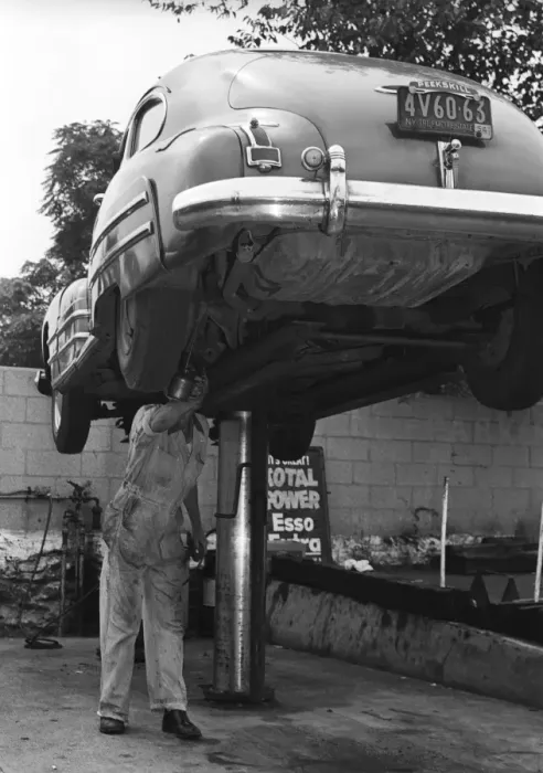 Framed Print : Mechanic working on underside of car Framed Print : Mechanic working on underside of car