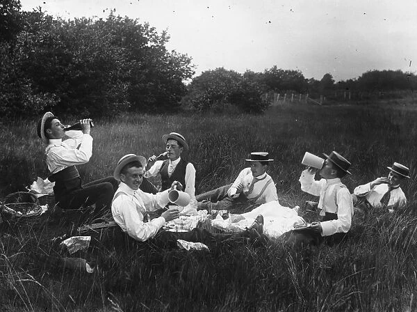 Men Only. A group of shirtsleeved men enjoying a picnic in a field