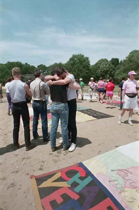 Framed Print : Two Men Embracing Near Memorial Quilt