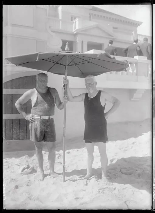 Framed Print : Two Men Holding a Beach Umbrella Framed Print : Two Men Holding a Beach Umbrella