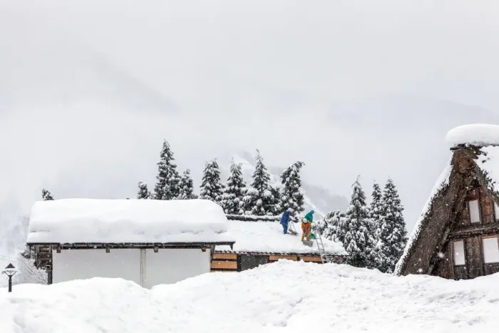 Framed Print : Men remove snow from roof during a winter storm