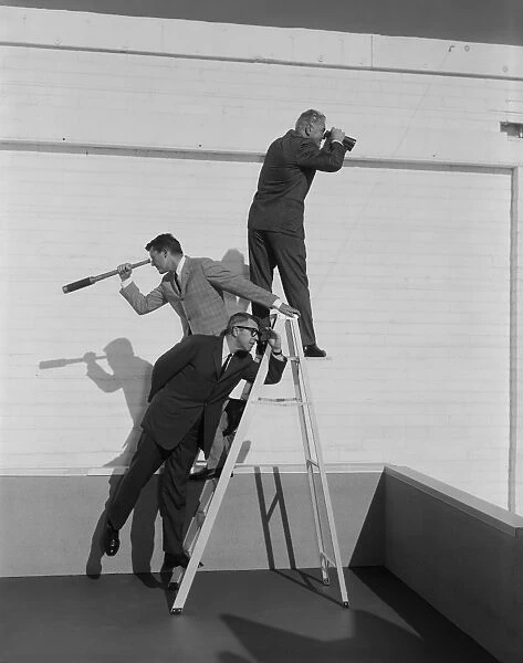 Men standing on ladder with binoculars and telescope