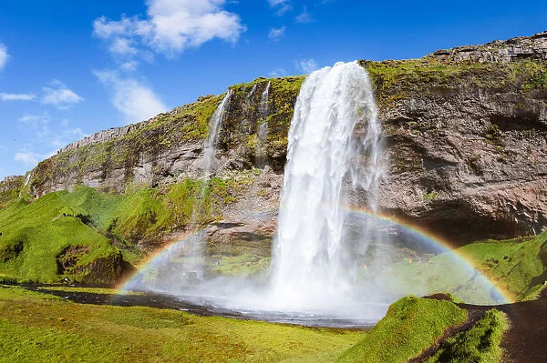 Mighty Seljalandsfoss waterfall with rainbow in summer, Iceland