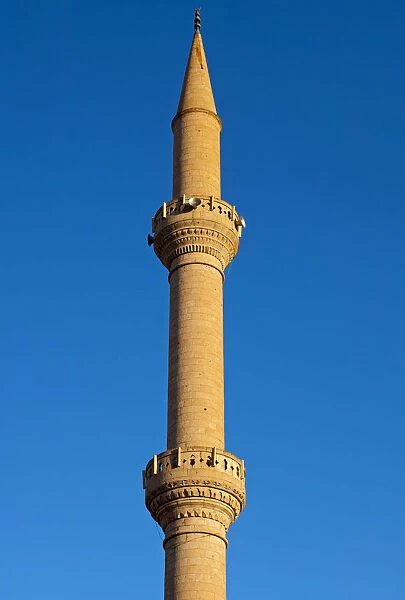 Minaret of a mosque protruding into the blue sky, Goreme, Cappadocia, Turkey