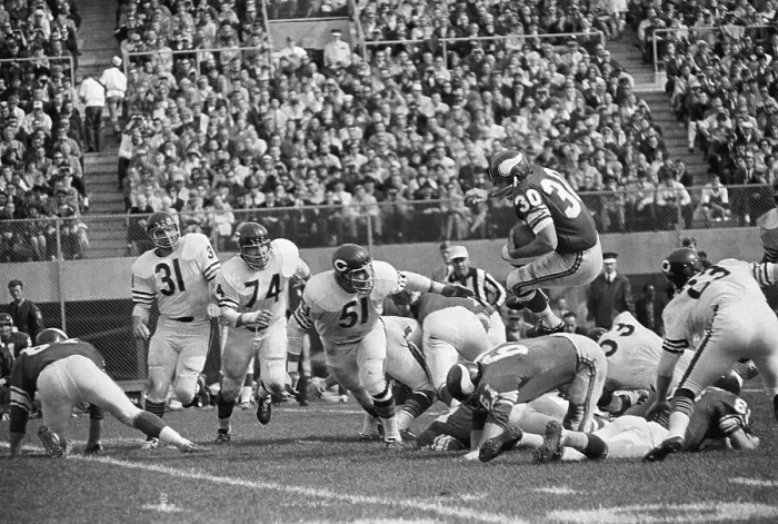 Framed Print : Minnesota Viking Player Leaps Over Opponents Framed Print : Minnesota Viking Player Leaps Over Opponents