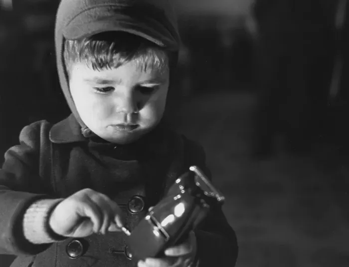 Framed Print : Model Car. December 1949: A young boy winding up the model motor car which Framed Print : Model Car. December 1949: A young boy winding up the model motor car which