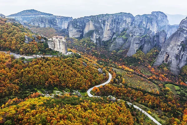 Monastery perched on a cliff with autumn coloured foliage