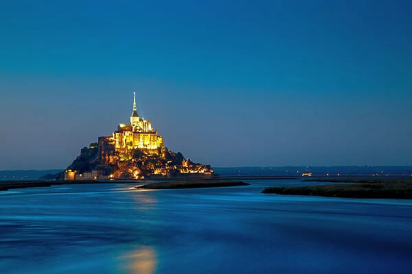Mont Saint-Michel at sunset with water in surround