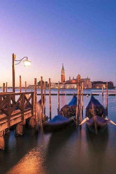 Moored gondolas in St Marks basin at sunrise. Venice, Veneto, Italy