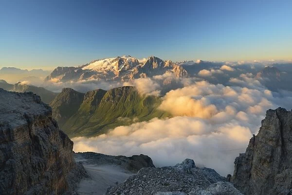 Morning mist in the valley below Marmolada peak, Dolomites