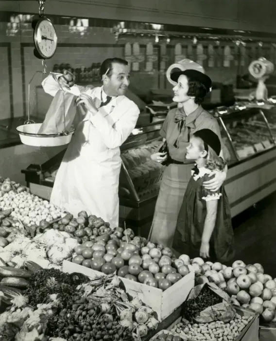 Framed Print : Mother and daughter in supermarket, shop assistant weighing groceries