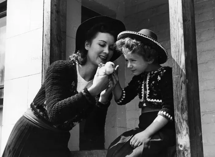 Framed Print : Chick. 30th August 1941: A mother holds a chick for her daughter to see Framed Print : Chick. 30th August 1941: A mother holds a chick for her daughter to see