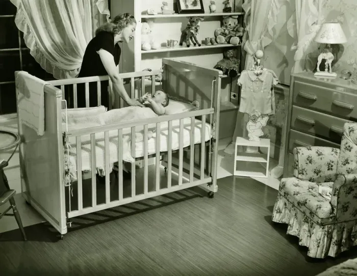 Framed Print : Mother looking at baby (3-6 months) lying in crib, (B&W) Framed Print : Mother looking at baby (3-6 months) lying in crib, (B&W)