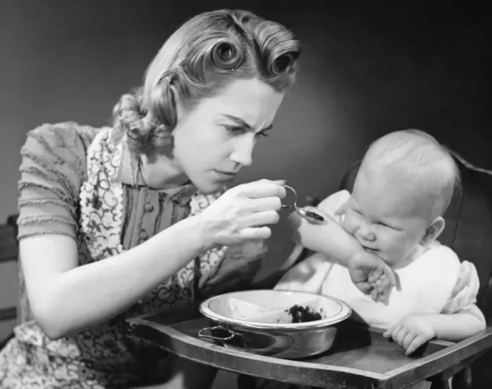 Framed Print : Mother trying to feed unwilling baby (9-12 months), (B&W) Framed Print : Mother trying to feed unwilling baby (9-12 months), (B&W)
