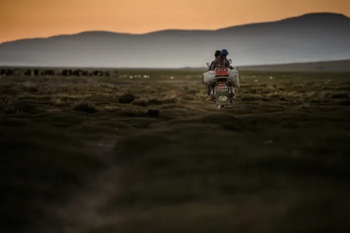 Framed Print : Motor bike riding on a field with sunset sky