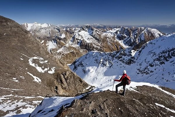Mountain climber on the summit ridge while descending from Wilde Kreuzspitze Mountain in the Pfunderer Mountains, overlooking the Vals Valley and Wurmaulspitz Mountain, Alto Adige, Italy, Europe