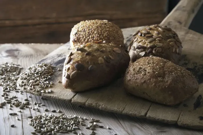 Framed Print : Multigrain bread rolls on old bread slide with rye grains Framed Print : Multigrain bread rolls on old bread slide with rye grains