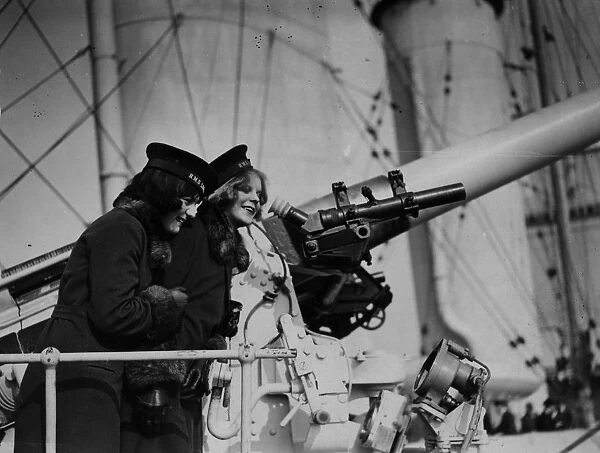 Naval Gun. 1929: Two women look at a gun on board HMS London
