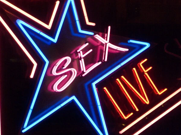 Neon sign in a red light district, with the lettering Sex Live