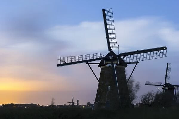 Netherlands, South Holland, Kinderdijk, View of windmills at sunset